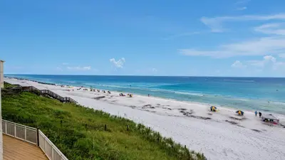 a beach with a bunch of people walking on it at Dune Villas 3B in Santa Rosa Beach