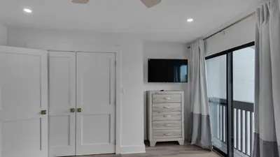 a white bedroom with a tv and a dresser at Dune Villas 3B in Santa Rosa Beach