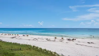 a group of people riding horses on the beach at Dune Villas 3B in Santa Rosa Beach