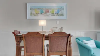a dining room table with two chairs and a lamp at Dune Villas 5A in Santa Rosa Beach