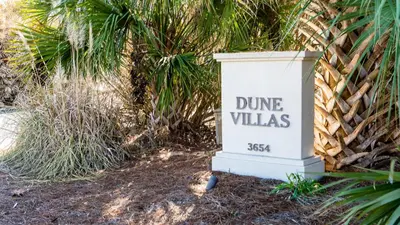 a sign that reads dine villas in front of a palm tree at Dune Villas 5A in Santa Rosa Beach