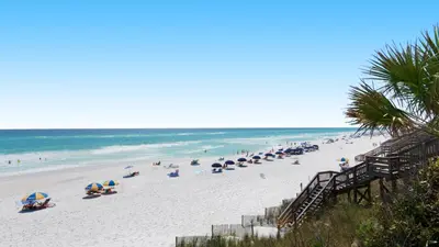 a beach with many umbrellas and people on it at Dune Villas 5A in Santa Rosa Beach