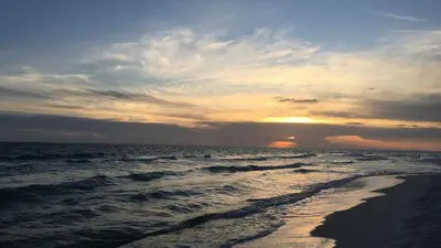 a sunset on the beach with the ocean at Dune Villas 5A in Santa Rosa Beach
