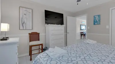 a bedroom with a bed and a dresser with a television at Dune Villas 5A in Santa Rosa Beach