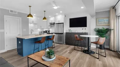 a kitchen with a blue island and a table at Emerald Hill 1 in Santa Rosa Beach