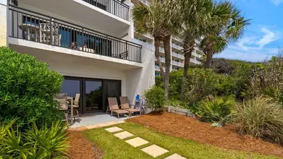 a building with a balcony with chairs and a patio at Emerald Hill 1 in Santa Rosa Beach
