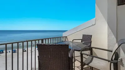 a balcony with a table and chairs and the beach at Emerald Hill 6 in Santa Rosa Beach