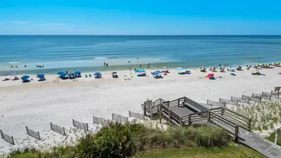 a group of people on a beach with umbrellas at Emerald Hill 6 in Santa Rosa Beach