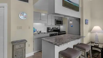 a kitchen with a counter and a sink and a clock at Emerald Hill 9 in Santa Rosa Beach