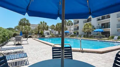 a pool with chairs and a table with an umbrella at Emerald Hill 11 in Santa Rosa Beach