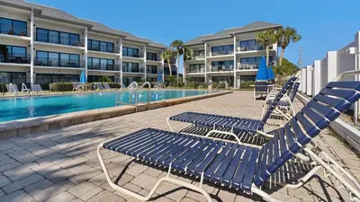 a group of blue chairs sitting next to a swimming pool at Emerald Hill 11 in Santa Rosa Beach