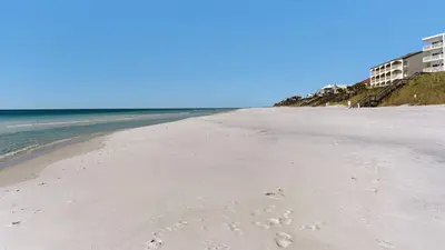 a beach with footprints in the sand next to the ocean at Emerald Hill 11 in Santa Rosa Beach
