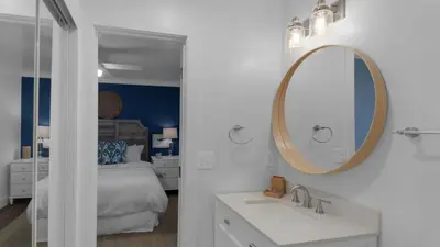 a white bathroom with a bed and a mirror at Eastern Shores 201 - A Happy Little Condo in Santa Rosa Beach