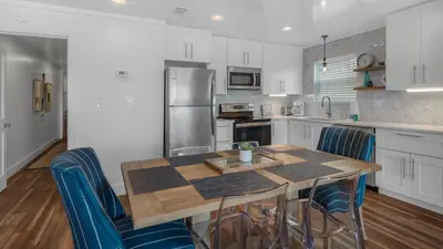 a kitchen with a wooden table and blue chairs at Eastern Shores 201 - A Happy Little Condo in Santa Rosa Beach