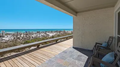 a porch with chairs and a view of the beach at Eastern Shores 201 - A Happy Little Condo in Santa Rosa Beach