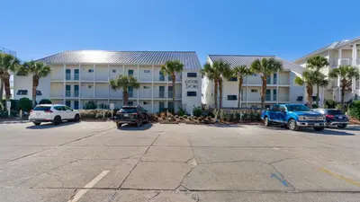 a parking lot in front of a building with palm trees at Eastern Shores 201 - A Happy Little Condo in Santa Rosa Beach
