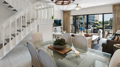 a living room with a glass table and chairs at Emerald Hill 36 in Santa Rosa Beach
