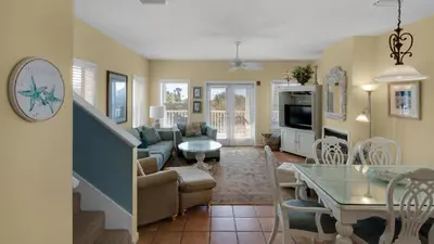 a living room with a couch and a dining room at Float Away in Panama City Beach
