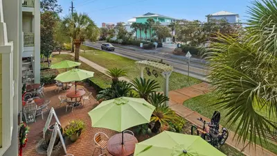a balcony with tables and chairs with umbrellas at Grand Isle 202 in Santa Rosa Beach