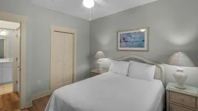 a bedroom with a white bed and two lamps at Grand Isle 202 in Santa Rosa Beach