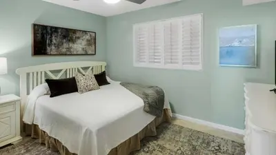 a bedroom with a white bed and a window at Tranquillity 340 in Panama City Beach