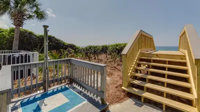 a beach house with a pool and a balcony at Tranquillity 340 in Panama City Beach