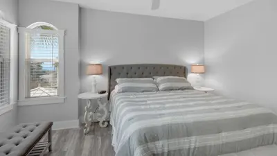 a white bedroom with a large bed and a window at Villas At Seagrove B201 - Emerald Dunes in Santa Rosa Beach