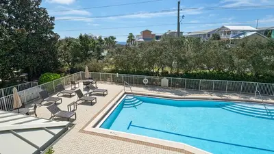 a large swimming pool with chairs and a table at Villas At Seagrove B201 - Emerald Dunes in Santa Rosa Beach