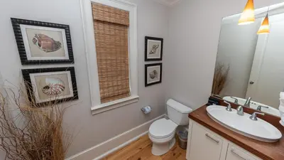 a bathroom with a sink and a toilet and a window at Tranquility at A La Paix in Panama City Beach