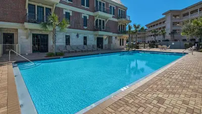 a large blue swimming pool in front of a building at Tranquility at A La Paix in Panama City Beach