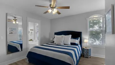 a bedroom with a blue and white bed with a ceiling fan at Monterey Condos A201 in Panama City Beach