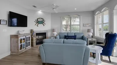a living room with a blue couch and a tv at Monterey Condos A201 in Panama City Beach