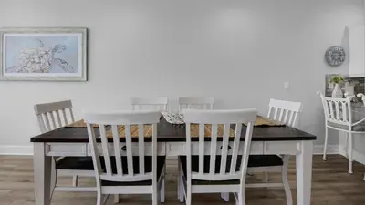 a dining room table with white chairs around it at Monterey Condos A201 in Panama City Beach