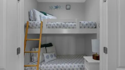 a room with two bunk beds and a ladder at Monterey Condos A201 in Panama City Beach