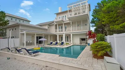 a large house with a swimming pool in front of it at Emotional Rescue in Inlet Beach