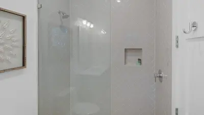 a shower with a glass door in a bathroom at Emotional Rescue in Inlet Beach