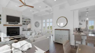 a living room with white furniture and a ceiling fan at Emotional Rescue in Inlet Beach
