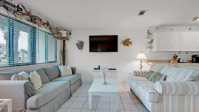 a living room with a couch and a table at Hidden Beach 103 in Santa Rosa Beach