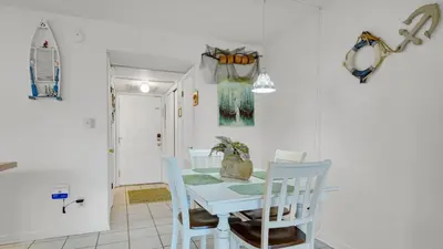 a dining room with a blue table and chairs at Hidden Beach 103 in Santa Rosa Beach