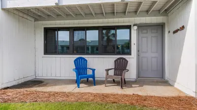 two blue chairs sitting on the porch of a house at Hidden Beach 103 in Santa Rosa Beach