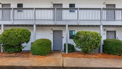 a white building with bushes in front of it at Hidden Beach 103 in Santa Rosa Beach
