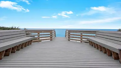a wooden boardwalk leading to the beach with two benches at Hidden Beach 103 in Santa Rosa Beach