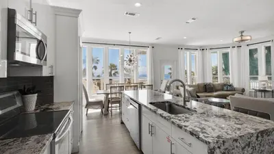 a kitchen and living room with a view of the ocean at The Mirage in Seacrest
