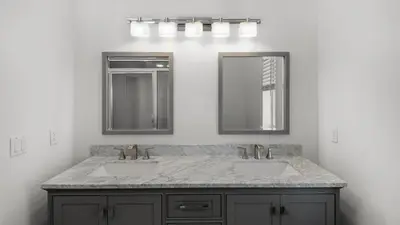 a bathroom with two sinks and two mirrors at The Mirage in Seacrest