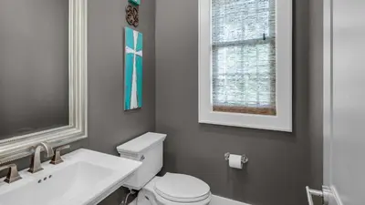 a bathroom with a toilet and a sink and a window at Sea Echo in Santa Rosa Beach