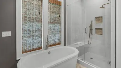 a white bathroom with a shower and a bath tub at Sea Echo in Santa Rosa Beach