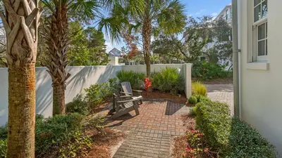 a bench sitting on a brick walkway next to a fence at Sea Echo in Santa Rosa Beach