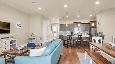a living room with a blue couch and a kitchen at Khalee-sea in Seacrest