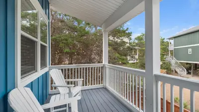 a porch with two white chairs on it at Khalee-sea in Seacrest