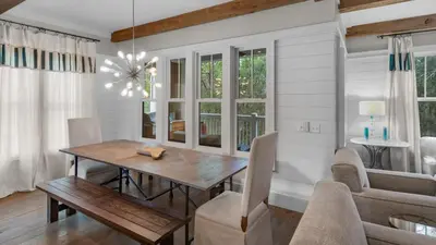 a dining room with a wooden table and chairs at Ocean Park in Santa Rosa Beach